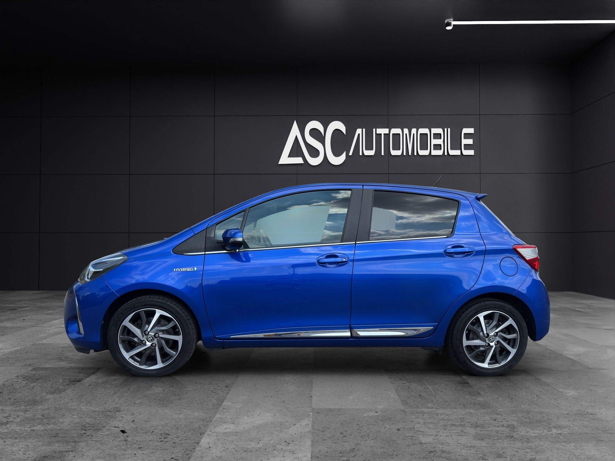 Toyota Yaris Hybrid in Blau von der linken Seite, fünftürig auf 16-Zoll-Leichtmetallfelgen