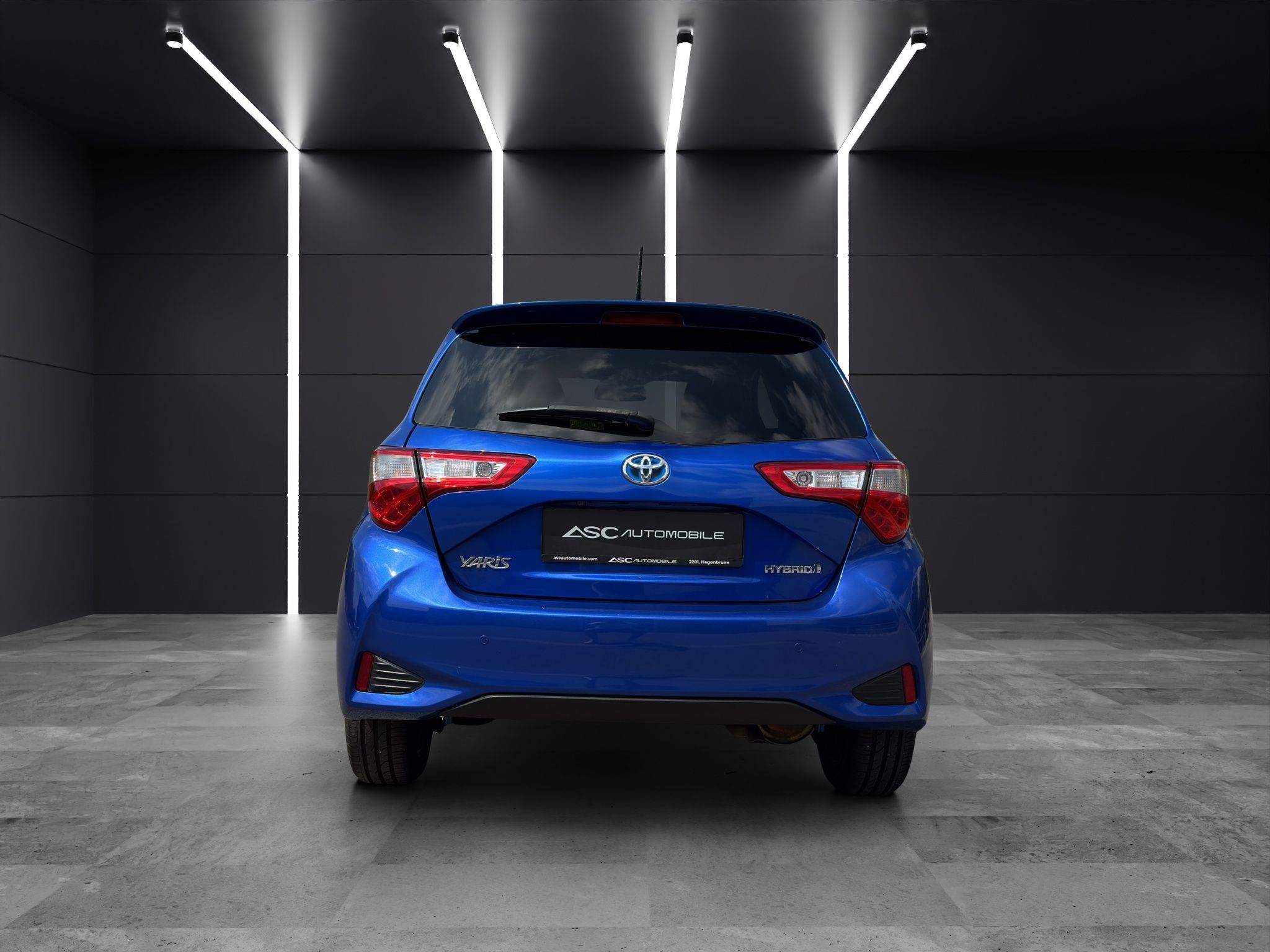 Heck des Toyota Yaris Hybrid in Blau mit LED-Rückleuchten und Toyota-Emblem