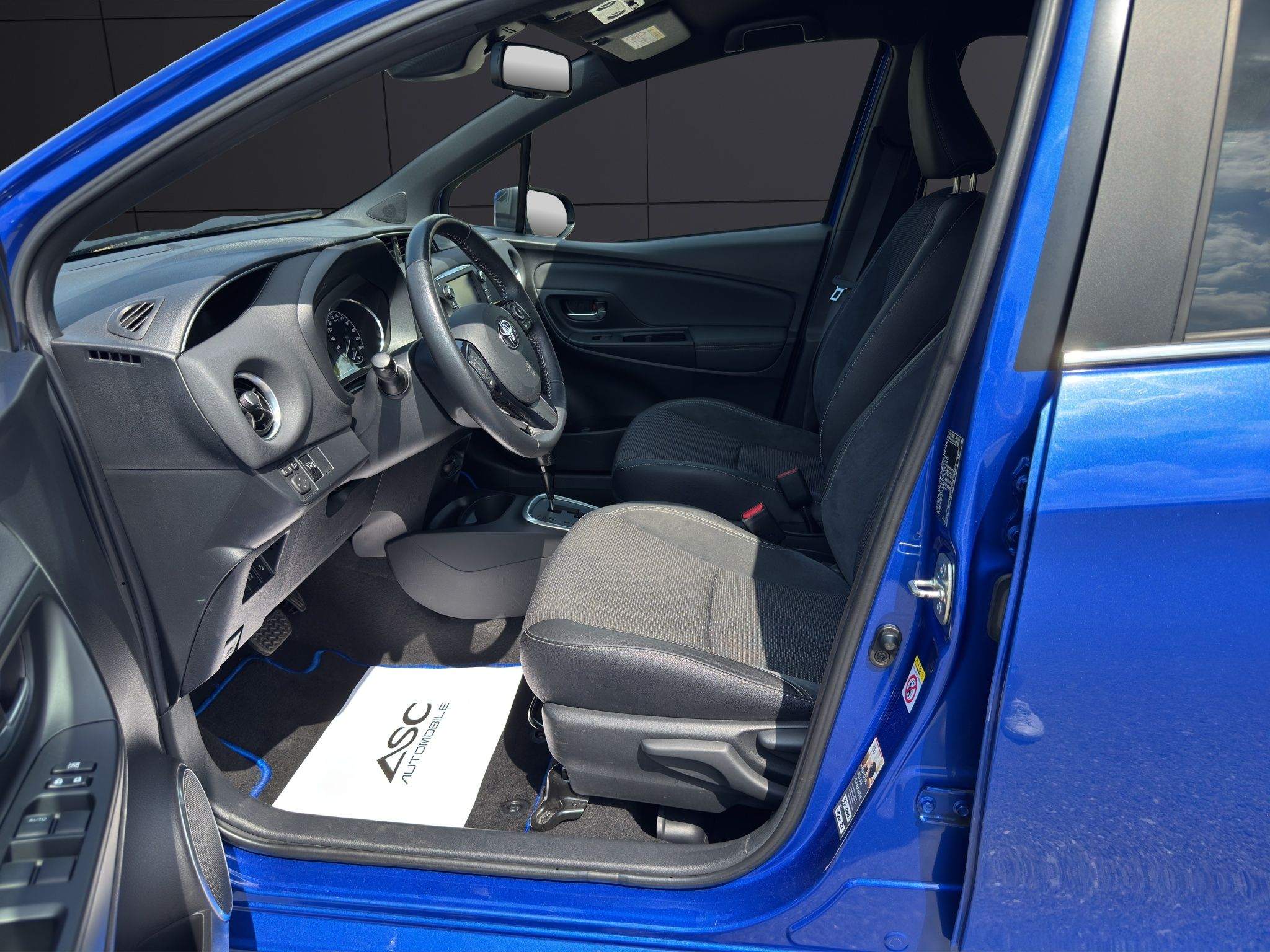 Blick durch die geöffnete Fahrertür auf den Fahrersitz des Toyota Yaris