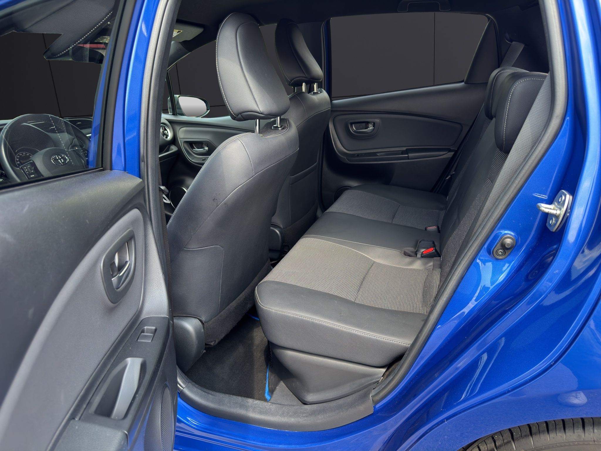 Fahrersitz des Toyota Yaris in grauem Stoff bei geöffneter Tür